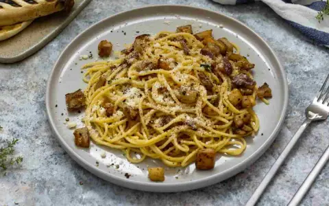 Spaghetti con melanzane fritte e ricotta salata, un sapore autentico di pasta alla siciliana.