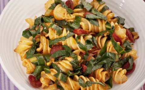 Fusilli conditi con bietole, salsiccia e un tocco di spezie. Un piatto saporito e colorato.