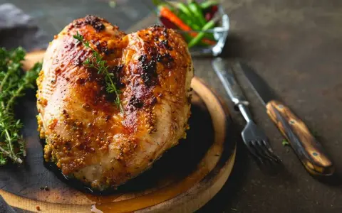 Succulento petto di pollo al forno, dorato e speziato, pronto per essere gustato con erbe aromatiche e peperoncini.