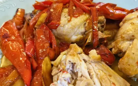 Succulento pollo alla romana con peperoni rossi arrostiti, un piatto saporito e colorato.