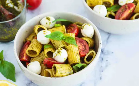 Un piatto di pasta pesto e pomodorini, con mozzarelline e basilico fresco. Un'esplosione di sapori mediterranei.
