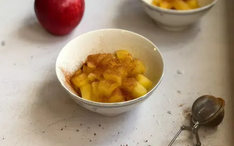 Mele cotte in pentola, dolci e profumate alla cannella, servite in una ciotola.