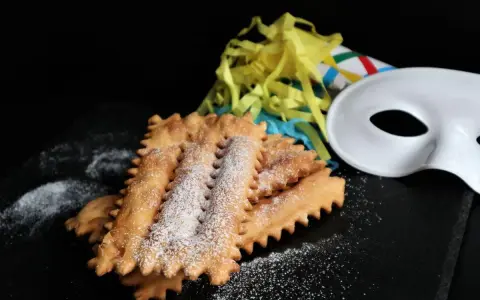 Chiacchiere siciliane spolverate di zucchero a velo, pronte per il Carnevale. La ricetta perfetta per festeggiare!