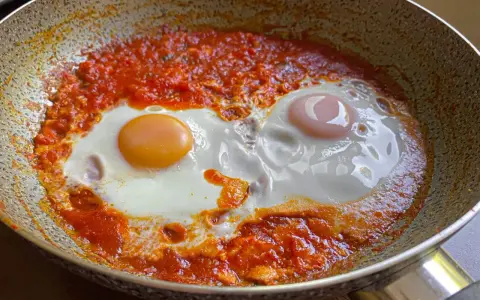 Uova in purgatorio, un piatto saporito con uova cotte in un sugo di pomodoro piccante, servite in padella.