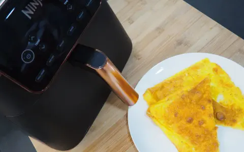 Frittata dorata appena sfornata dalla friggitrice ad aria Ninja, pronta per essere gustata.