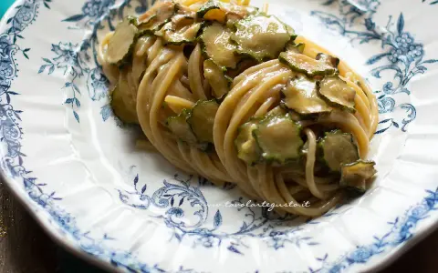 Spaghetti alla Nerano, un classico piatto campano con zucchine cremose e profumate, servito su un piatto decorato.
