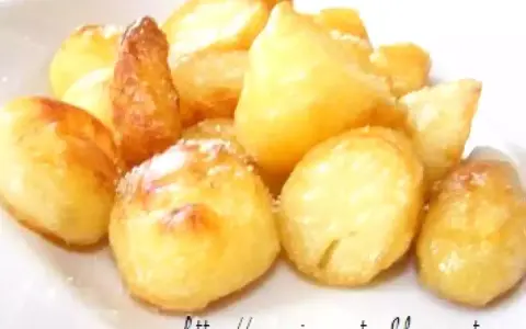Un mucchio di patate al forno dorate e croccanti, cosparse di un po' di sale, pronte per essere gustate.
