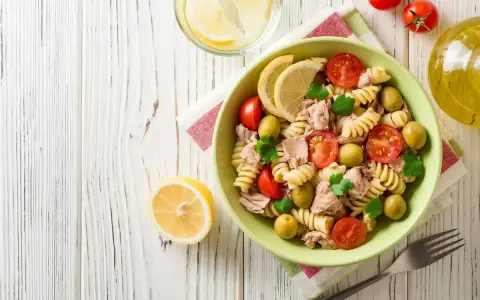Deliziosa pasta fredda con tonno, pomodorini, olive e limone, perfetta per un pasto estivo.