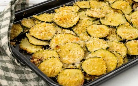 Fette di zucchine gratinate al forno, dorate e croccanti, pronte per essere gustate.