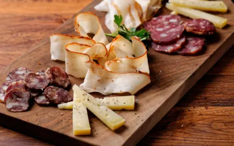 Un invitante tagliere di salumi per aperitivo con formaggio e salame, pronto per essere gustato.