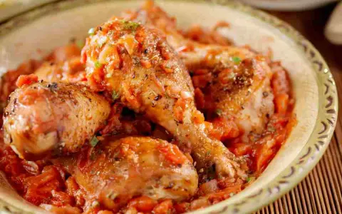 Pezzi di pollo succulenti immersi in una ricca salsa di pomodoro e verdure, un invitante pollo alla cacciatora.