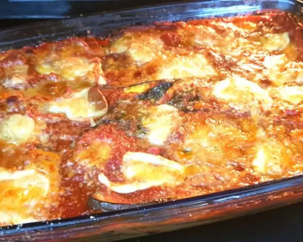 Parmigiana di melanzane non fritte appena sfornata, dorata e filante, pronta per essere gustata.