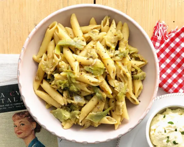 Penne con carciofi in una salsa cremosa, condite con pepe nero. Un piatto che sa di casa e tradizione.