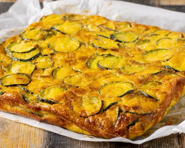 Frittata di zucchine dorata e invitante, con fette di zucchine ben visibili sulla superficie, pronta per essere gustata.