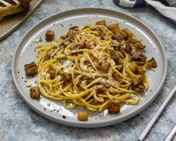 Spaghetti con melanzane fritte e ricotta salata, un sapore autentico di pasta alla siciliana.