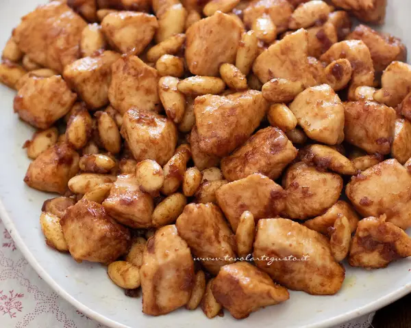 Un invitante pollo alle mandorle, con bocconcini dorati e mandorle tostate, conditi con una salsa lucida.