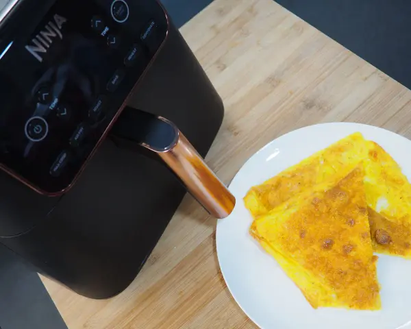 Frittata dorata appena sfornata dalla friggitrice ad aria Ninja, pronta per essere gustata.