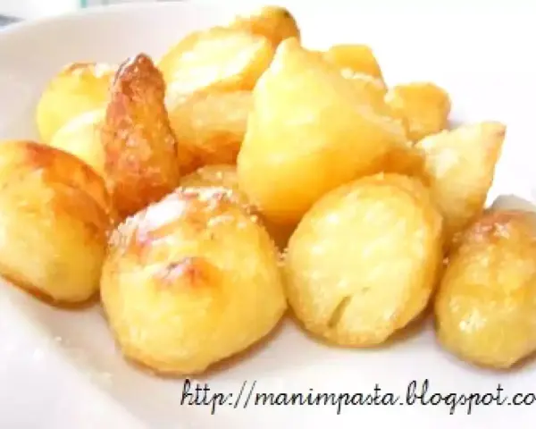 Un mucchio di patate al forno dorate e croccanti, cosparse di un po' di sale, pronte per essere gustate.