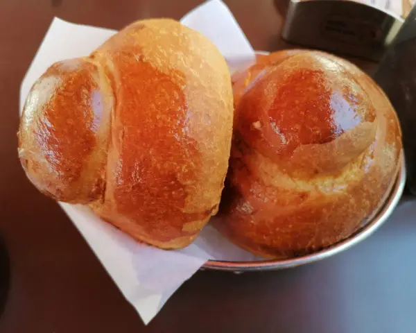 Due brioche col tuppo dorate e lucide, pronte per essere gustate con una granita.