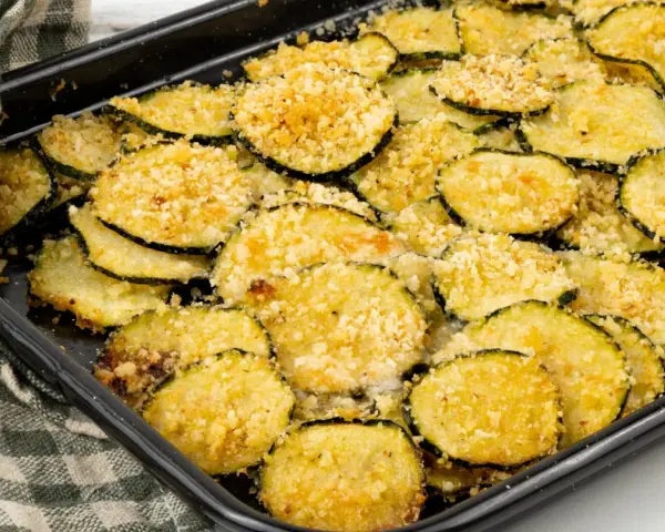 Fette di zucchine gratinate al forno, dorate e croccanti, pronte per essere gustate.