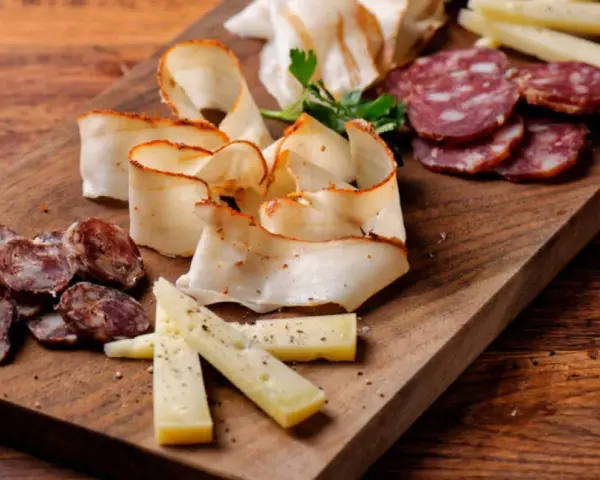 Un invitante tagliere di salumi per aperitivo con formaggio e salame, pronto per essere gustato.