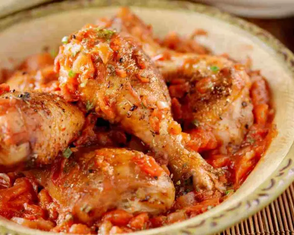 Pezzi di pollo succulenti immersi in una ricca salsa di pomodoro e verdure, un invitante pollo alla cacciatora.