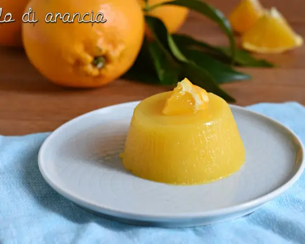 Delizioso gelo di arancia, un dolce fresco e profumato, guarnito con una fetta d'arancia.