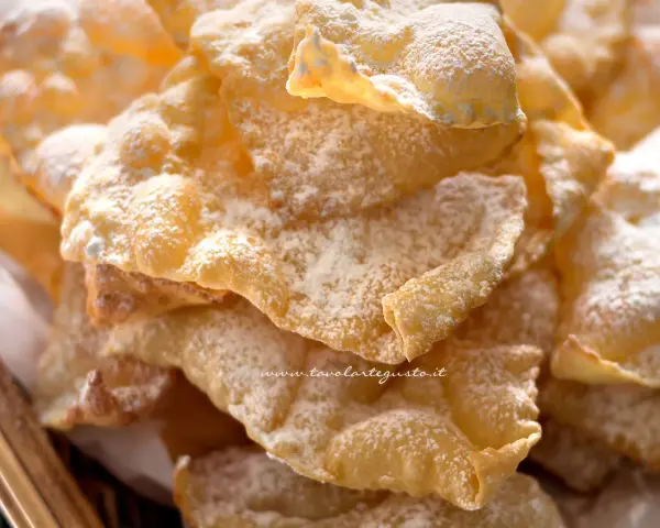 Un mucchio di chiacchiere croccanti, spolverate di zucchero a velo, pronte per essere gustate. La ricetta originale delle bugie.