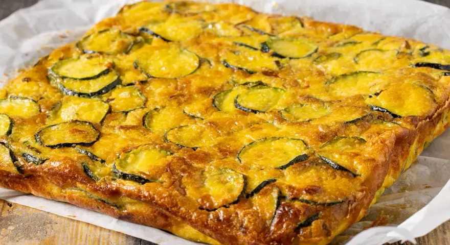 Frittata di zucchine dorata e invitante, con fette di zucchine ben visibili sulla superficie, pronta per essere gustata.