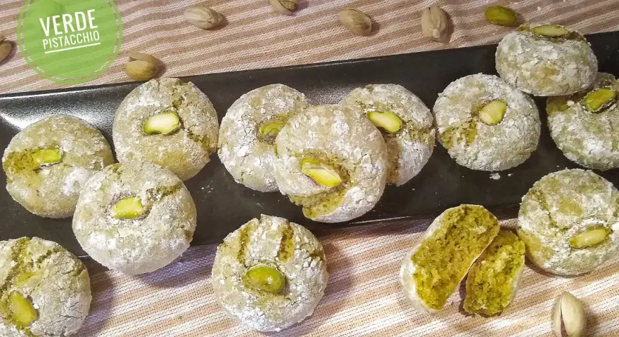 Biscotti al pistacchio siciliani, dolci e friabili, con un cuore verde intenso e un pistacchio intero in cima.