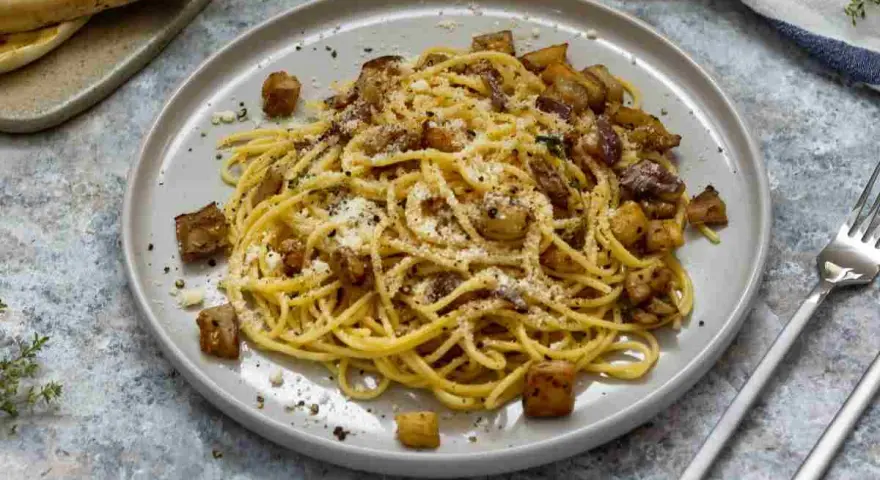 Spaghetti con melanzane fritte e ricotta salata, un sapore autentico di pasta alla siciliana.