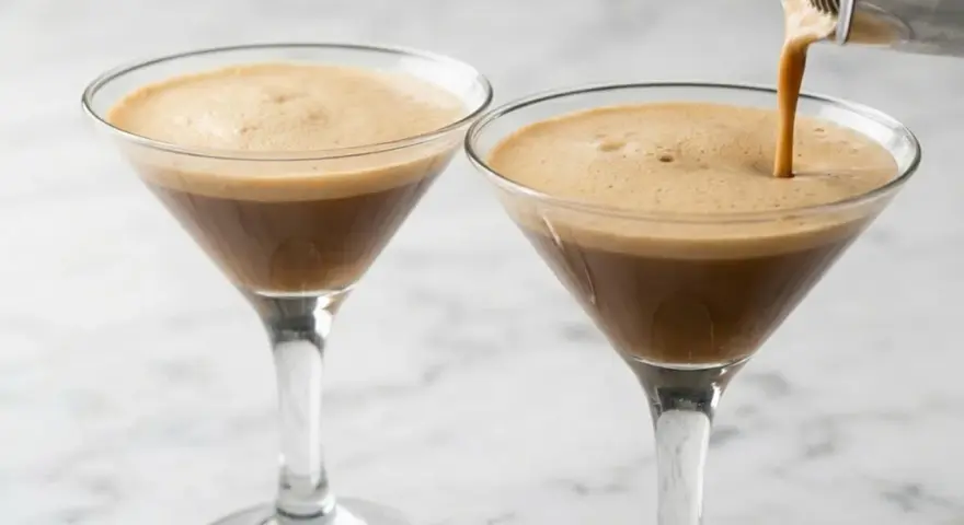 Due bicchieri di **caffè shakerato** con una schiuma densa e invitante. Uno viene riempito da uno shaker.