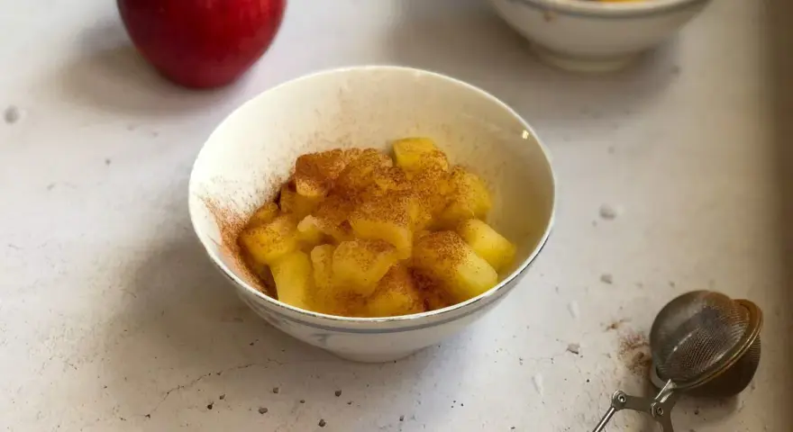 Mele cotte in pentola, dolci e profumate alla cannella, servite in una ciotola.