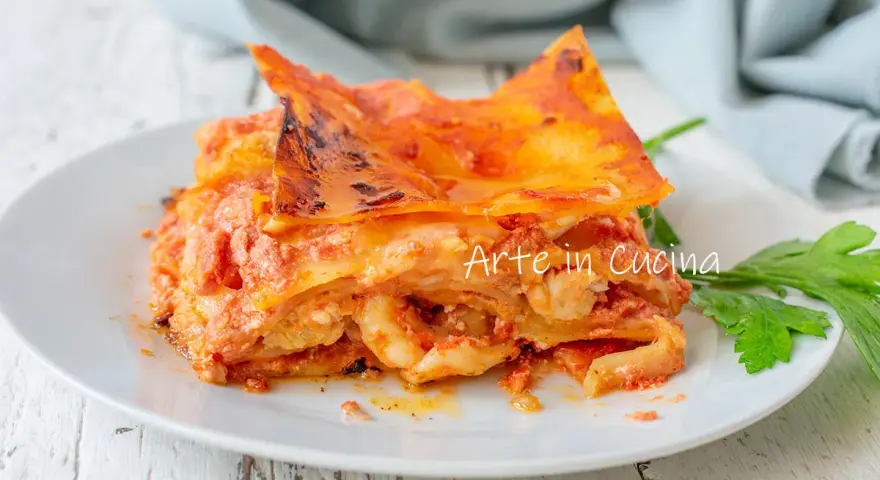 Una fetta di lasagna di mare napoletana, ricca e saporita, servita su un piatto bianco con un rametto di prezzemolo.