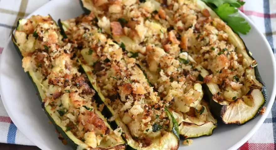 Zucchine ripiene al forno, dorate e croccanti, con un ripieno saporito e erbe aromatiche. Un piatto invitante e gustoso.
