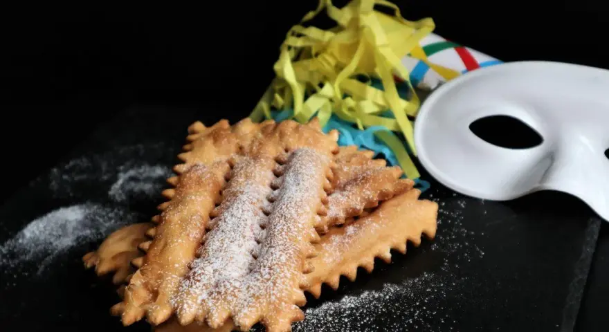 Chiacchiere siciliane spolverate di zucchero a velo, pronte per il Carnevale. La ricetta perfetta per festeggiare!
