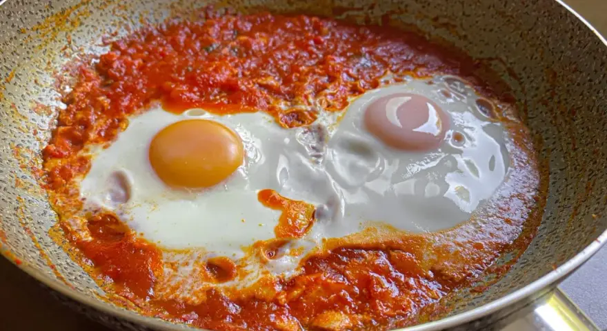 Uova in purgatorio, un piatto saporito con uova cotte in un sugo di pomodoro piccante, servite in padella.