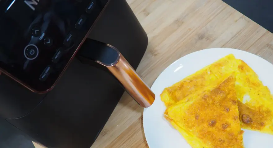 Frittata dorata appena sfornata dalla friggitrice ad aria Ninja, pronta per essere gustata.