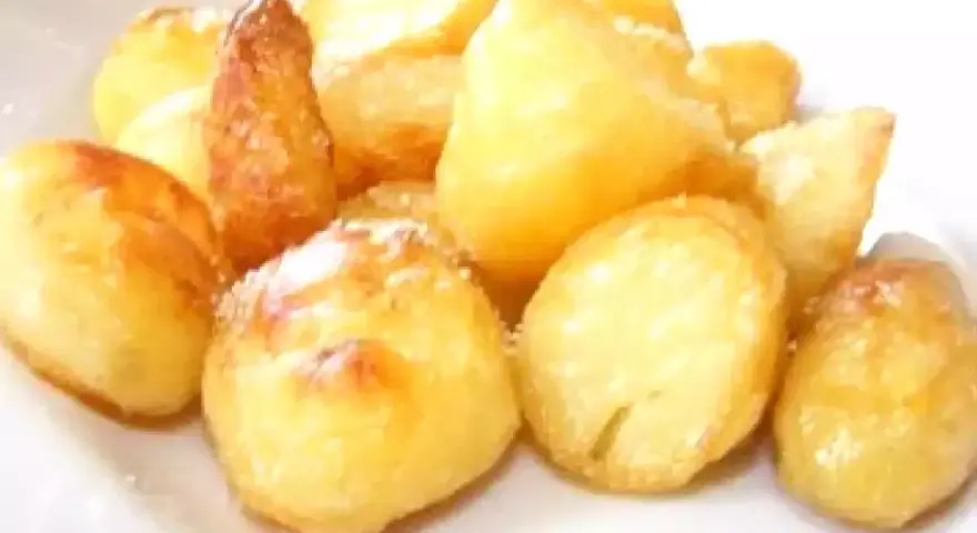 Un mucchio di patate al forno dorate e croccanti, cosparse di un po' di sale, pronte per essere gustate.