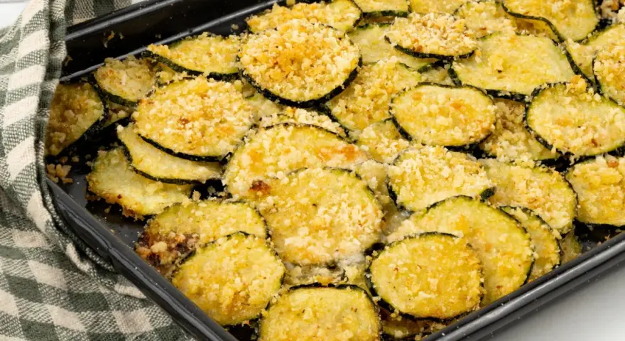 Fette di zucchine gratinate al forno, dorate e croccanti, pronte per essere gustate.