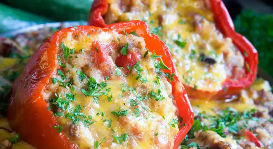 Peperoni ripieni senza carne, dorati e filanti, guarniti con prezzemolo fresco. Un piatto gustoso e leggero.