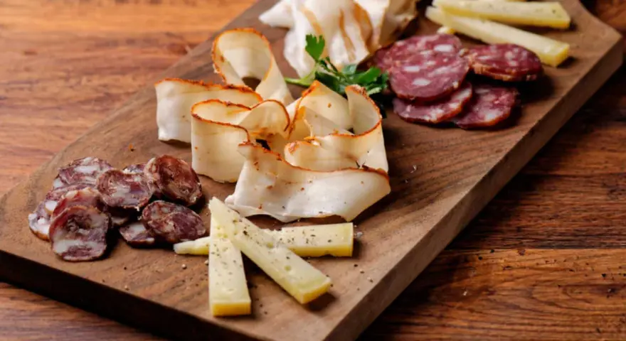 Un invitante tagliere di salumi per aperitivo con formaggio e salame, pronto per essere gustato.