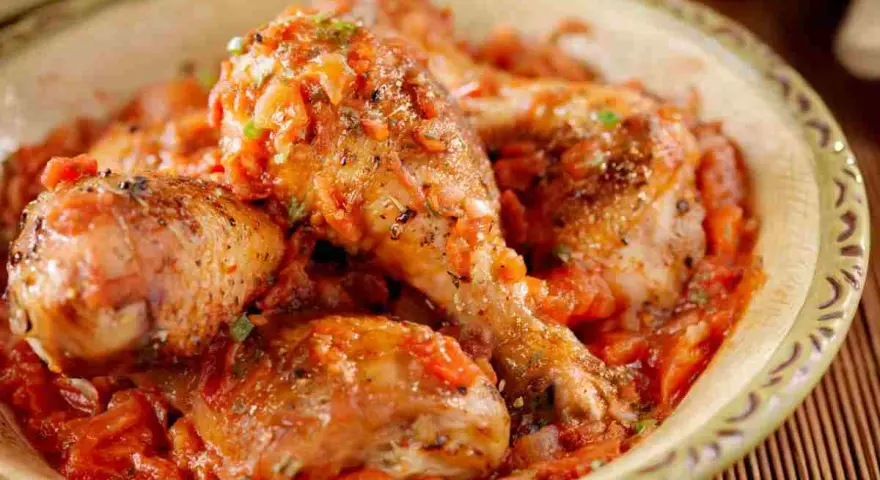 Pezzi di pollo succulenti immersi in una ricca salsa di pomodoro e verdure, un invitante pollo alla cacciatora.