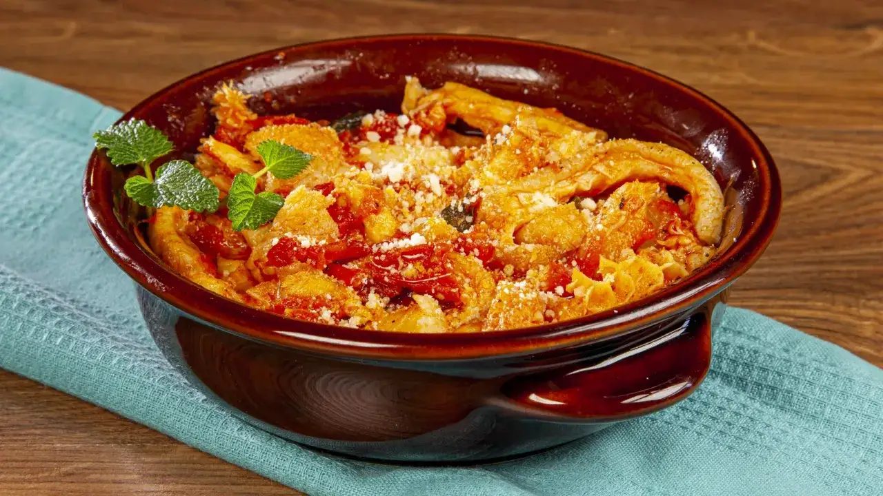 Trippa alla romana fumante in ciotola di terracotta, guarnita con menta fresca e abbondante pecorino grattugiato.