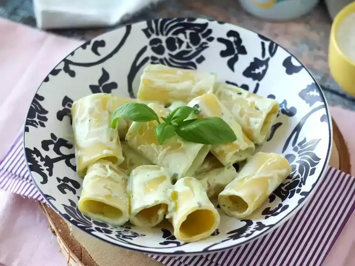 Piatto di paccheri cremosi con ricotta e basilico fresco, un classico della cucina italiana.