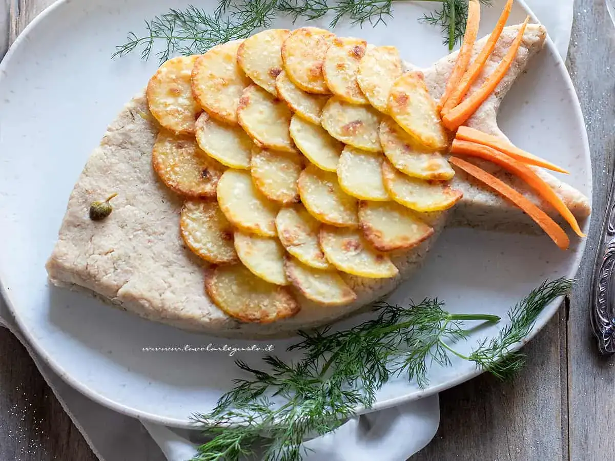 Un pesce finto ricetta, con scaglie di patate dorate e carote per la coda, un piatto divertente e gustoso.