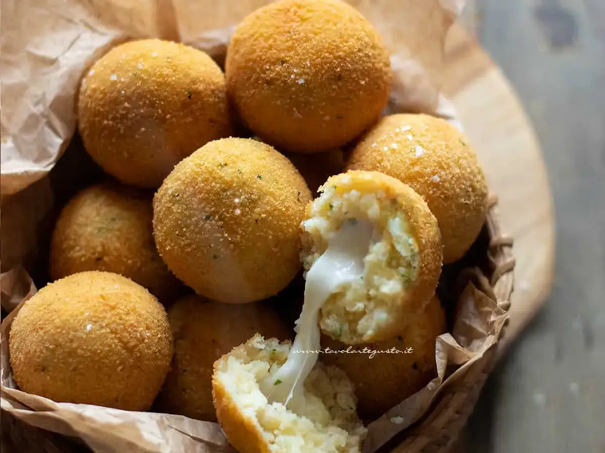 Polpette di patate dorate e croccanti, una con il cuore filante di formaggio.