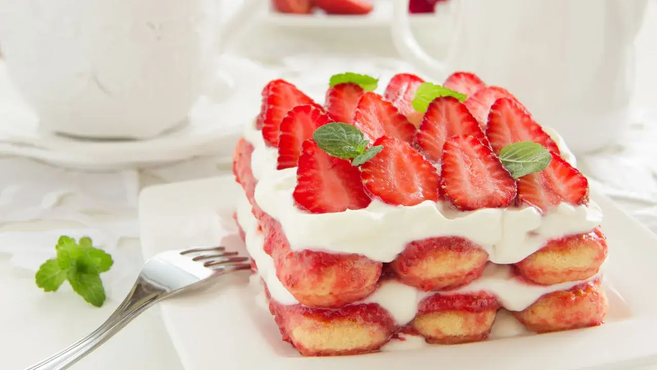 Delizioso tiramis&ugrave; alle fragole, stratificato con savoiardi, crema e fragole fresche, guarnito con menta.