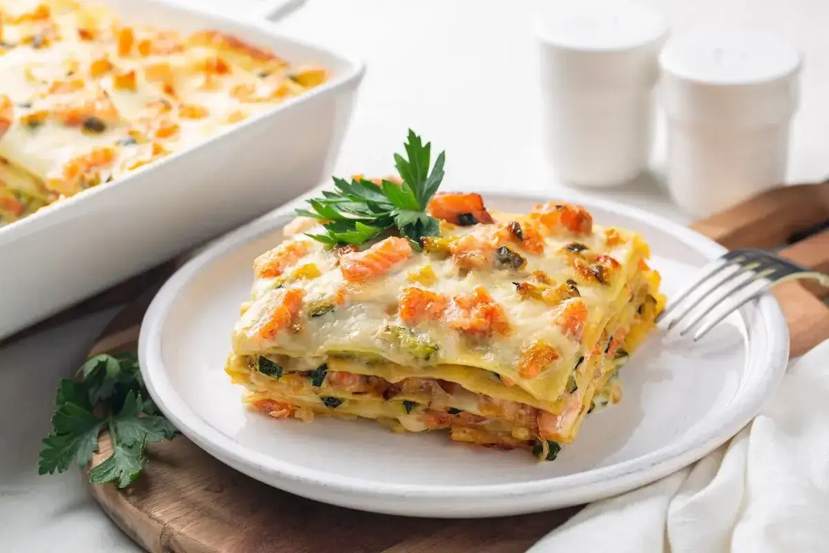 Una fetta di lasagna di mare napoletana, ricca di pesce e verdure, guarnita con prezzemolo fresco.
