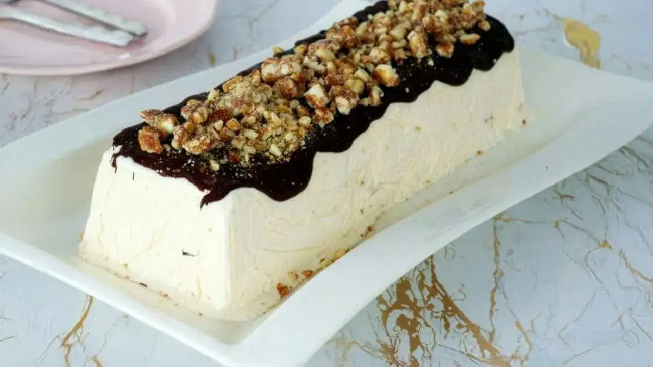 Parfait di mandorle ricoperto di cioccolato fuso e granella croccante. Un dolce freddo invitante.